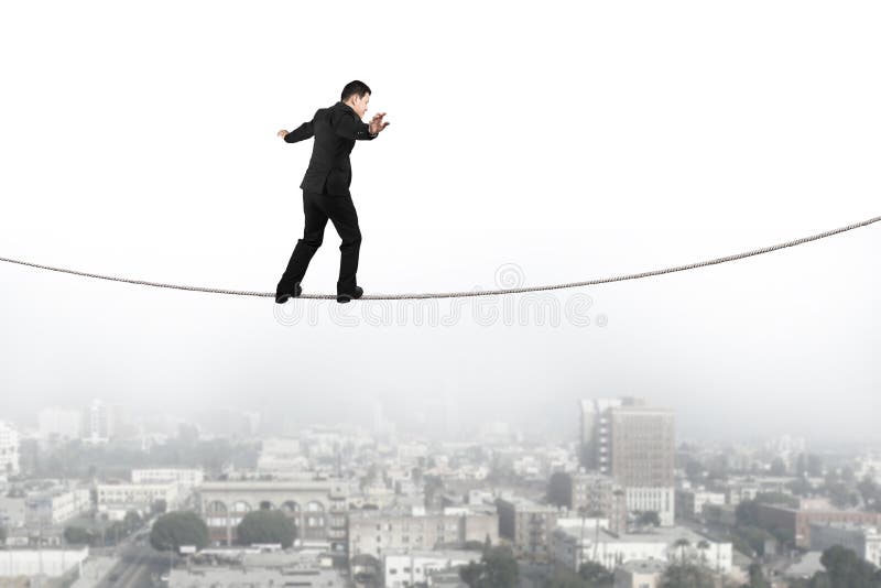 Homem de negócios que equilibra e que anda na corda com cena urbana foto de stock Homem de negócios que equilibra e que anda na corda com cena urbana foto de stock