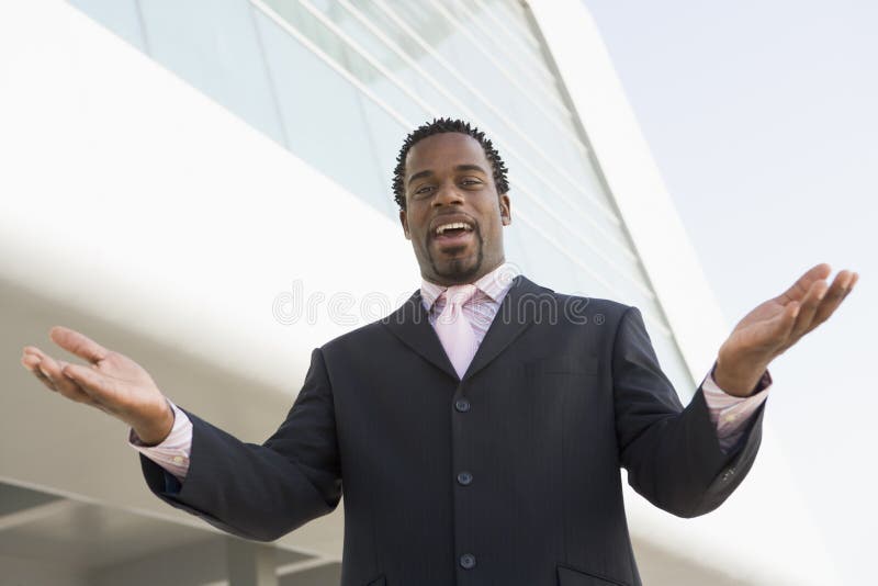 Homem de negócios que está ao ar livre pelo edifício foto de stock royalty free Homem de negócios que está ao ar livre pelo edifício foto de stock royalty free