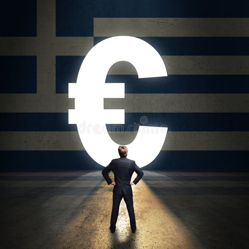 Homem de negócios que está na frente de um portal dado forma como o Euro na frente de uma parede pintada com a bandeira grega fotos de stock Homem de negócios que está na frente de um portal dado forma como o Euro na frente de uma parede pintada com a bandeira grega fotos de stock