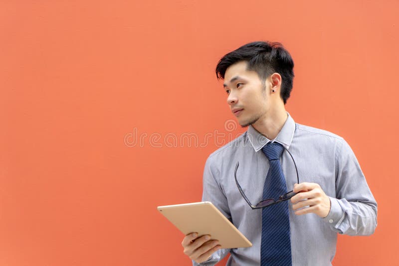 Homem de negócios que guarda o tablet pc digital no fundo com c imagens de stock royalty free Homem de negócios que guarda o tablet pc digital no fundo com c imagens de stock royalty free