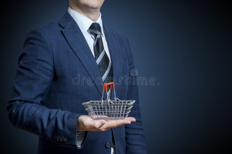 Homem de negócios que guarda um cesto de compras em sua mão imagens de stock Homem de negócios que guarda um cesto de compras em sua mão imagens de stock