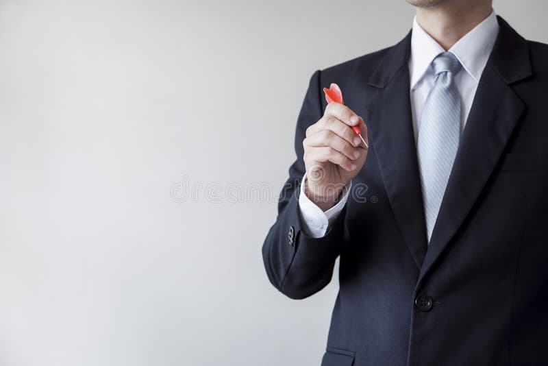 Homem de negócios que guarda um dardo foto de stock royalty free Homem de negócios que guarda um dardo foto de stock royalty free