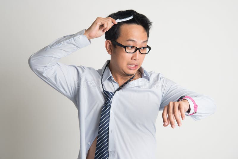 Homem de negócios que penteia o cabelo na manhã na pressa imagem de stock Homem de negócios que penteia o cabelo na manhã na pressa imagem de stock