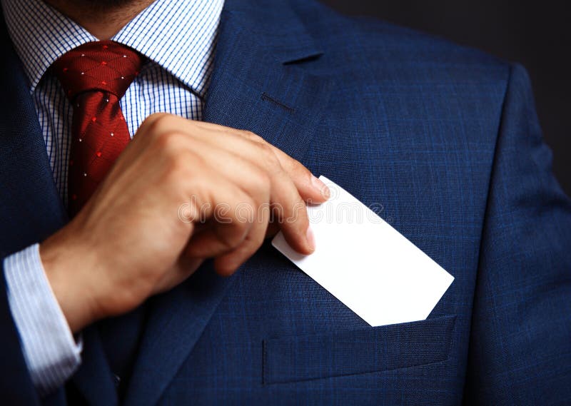 Homem de negócios que põe o cartão da visita no bolso foto de stock royalty free Homem de negócios que põe o cartão da visita no bolso foto de stock royalty free