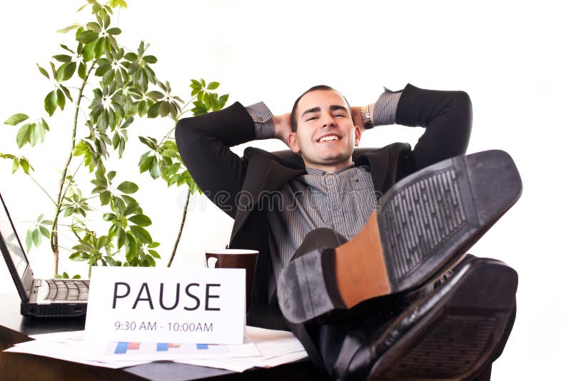 Homem de negócios que relaxa no escritório foto de stock Homem de negócios que relaxa no escritório foto de stock