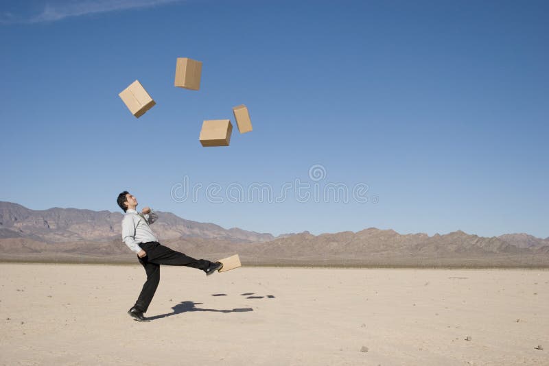 Businessman kicking boxes in the air. Businessman kicking boxes in the air