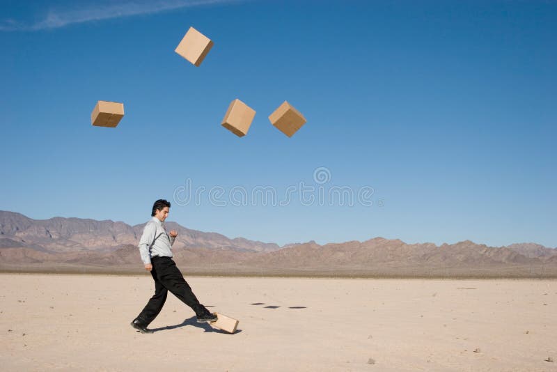 Businessman kicking cardboard boxes in the air. Businessman kicking cardboard boxes in the air
