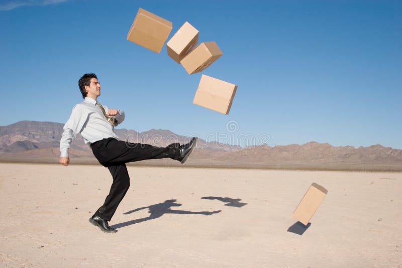 Businessman kicking boxes in the air. Businessman kicking boxes in the air