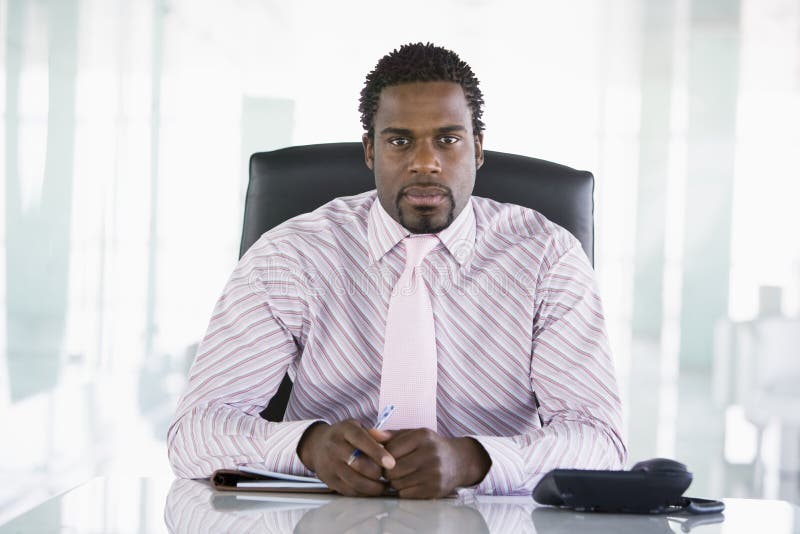 Homem de negócios que senta-se no escritório imagem de stock royalty free Homem de negócios que senta-se no escritório imagem de stock royalty free