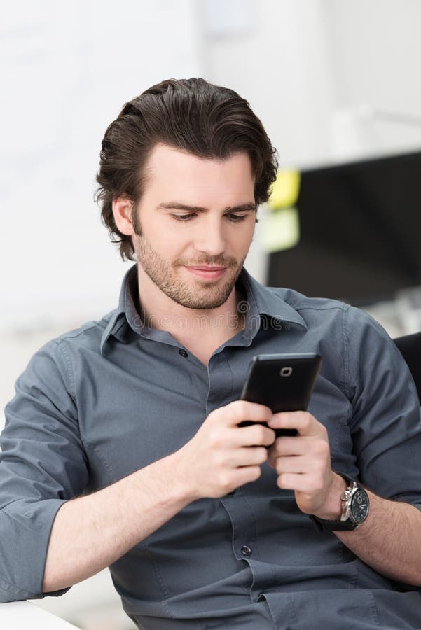 Homem de negócios que texting em seu telefone celular imagens de stock Homem de negócios que texting em seu telefone celular imagens de stock