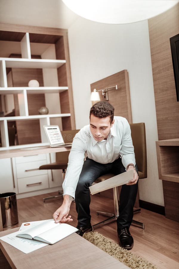 Homem de negócios que toma seu caderno ao trabalhar no hotel imagem de stock royalty free Homem de negócios que toma seu caderno ao trabalhar no hotel imagem de stock royalty free
