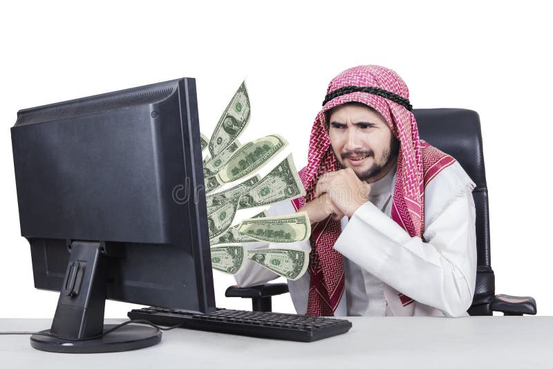 Homem de negócios árabe com dinheiro em seu computador foto de stock royalty free Homem de negócios árabe com dinheiro em seu computador foto de stock royalty free