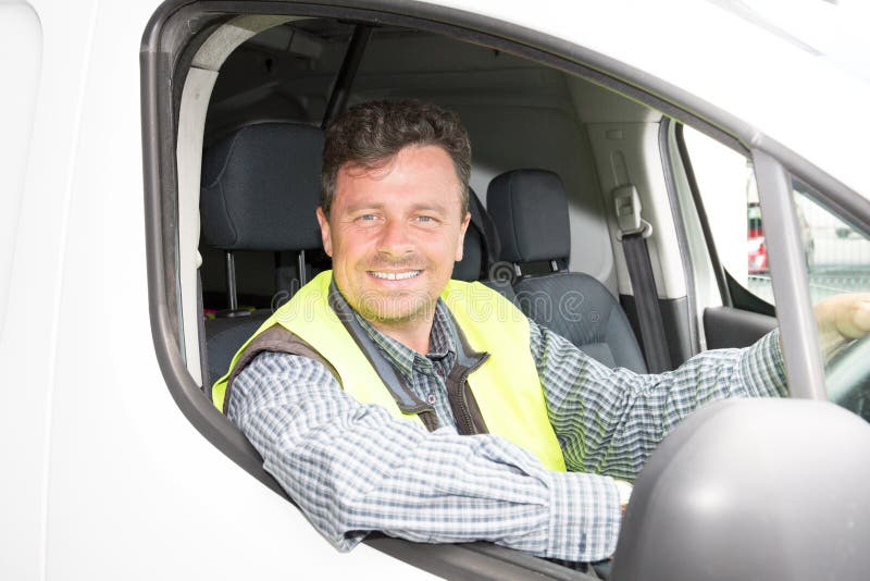 Homem de sorriso do motorista da entrega que conduz sua camionete foto de stock royalty free Homem de sorriso do motorista da entrega que conduz sua camionete foto de stock royalty free