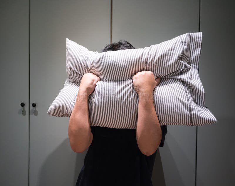 Homem deprimido que cobre sua cara com o descanso e que grita na raiva foto de stock Homem deprimido que cobre sua cara com o descanso e que grita na raiva foto de stock