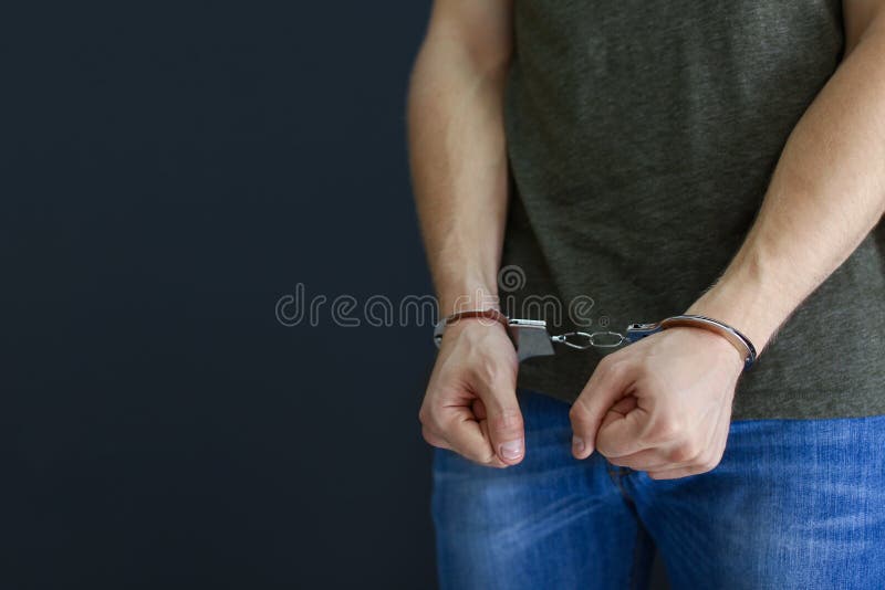 Homem detido nas algemas dentro Lei criminal imagem de stock Homem detido nas algemas dentro Lei criminal imagem de stock