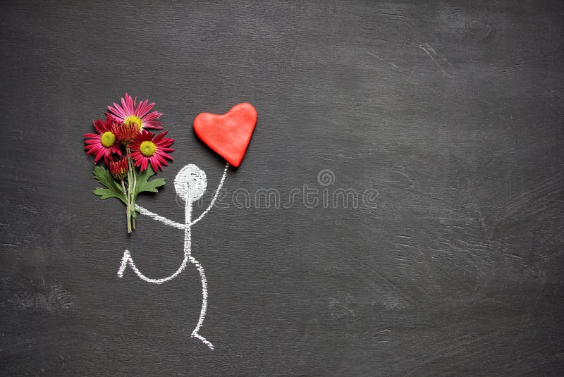 Homem do desenho de giz com o ramalhete das flores e do coração vermelho grande no fundo do quadro com espaço da cópia Presente d imagens de stock Homem do desenho de giz com o ramalhete das flores e do coração vermelho grande no fundo do quadro com espaço da cópia Presente d imagens de stock