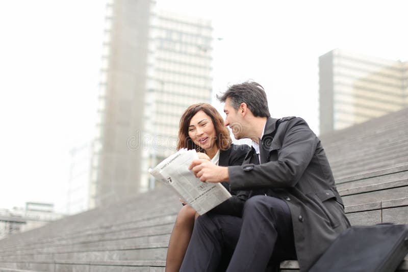 homem dos coordenadores e artigo fêmea da leitura sobre a empresa dentro imagens de stock royalty free homem dos coordenadores e artigo fêmea da leitura sobre a empresa dentro imagens de stock royalty free
