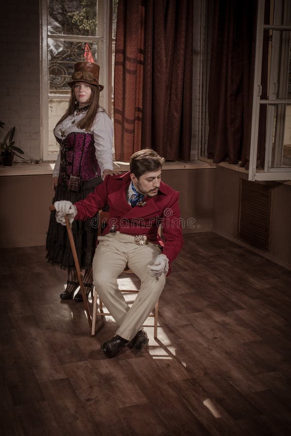 Homem e mulher vestidos na roupa no estilo do steampunk fotografia de stock Homem e mulher vestidos na roupa no estilo do steampunk fotografia de stock