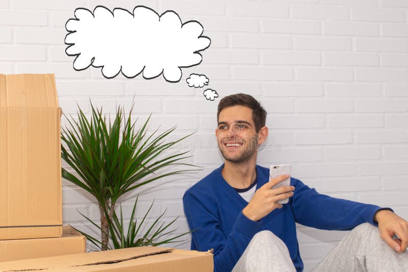 Homem em mudança de casa pensando no telefone celular fotografia de stock royalty free