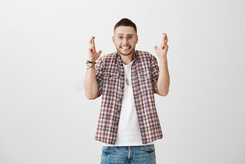 Homem emotivo nos vidros e no equipamento à moda nervosamente que cruzam os dedos, estando sob a pressão, implorando ou desejando imagens de stock royalty free Homem emotivo nos vidros e no equipamento à moda nervosamente que cruzam os dedos, estando sob a pressão, implorando ou desejando imagens de stock royalty free