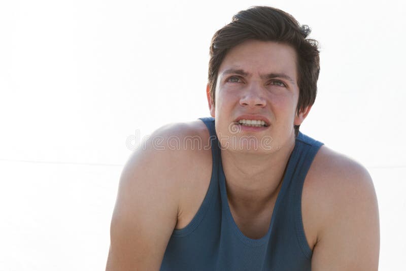 Homem esgotado que toma uma ruptura após movimentar-se na praia fotos de stock royalty free Homem esgotado que toma uma ruptura após movimentar-se na praia fotos de stock royalty free