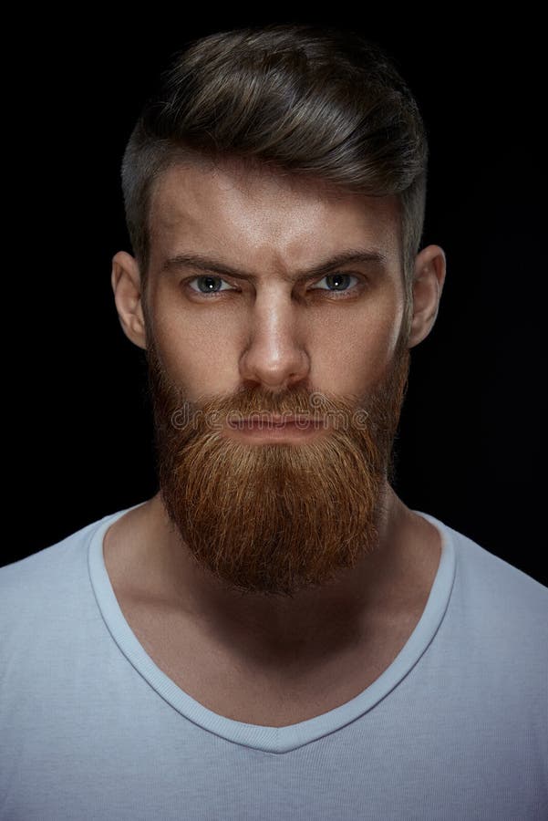 Homem farpado brutal em um t-shirt branco imagem de stock Homem farpado brutal em um t-shirt branco imagem de stock