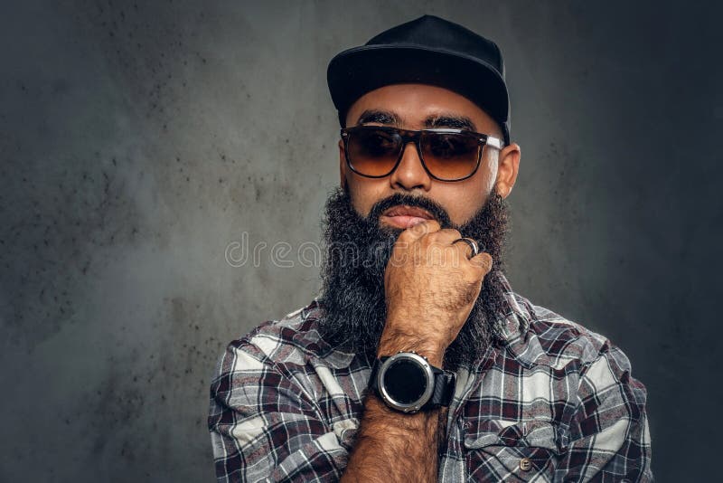 Homem farpado preto que levanta sobre o fundo cinzento imagens de stock Homem farpado preto que levanta sobre o fundo cinzento imagens de stock