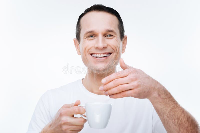Homem feliz alegre que aprecia o cheiro do café imagem de stock royalty free Homem feliz alegre que aprecia o cheiro do café imagem de stock royalty free