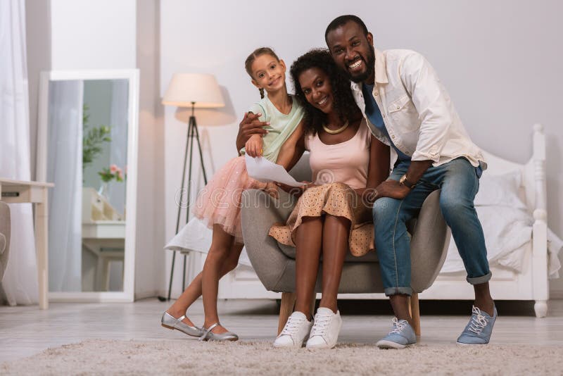 Homem feliz deleitado que abraça sua família em casa imagens de stock Homem feliz deleitado que abraça sua família em casa imagens de stock