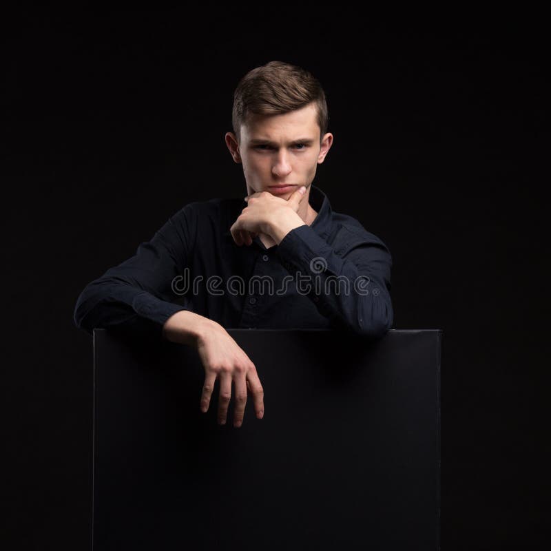 Homem feliz novo que mostra a apresentação, apontando no cartaz sobre g foto de stock Homem feliz novo que mostra a apresentação, apontando no cartaz sobre g foto de stock