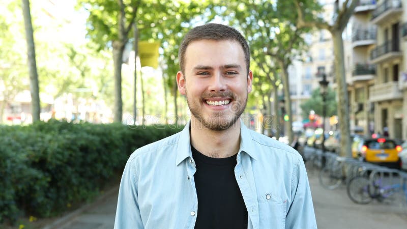 Homem feliz que ri da câmera na rua