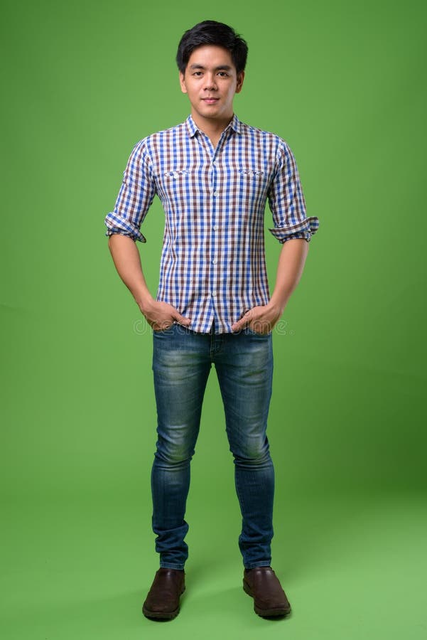 Homem filipino considerável novo contra o fundo verde foto de stock royalty free Homem filipino considerável novo contra o fundo verde foto de stock royalty free