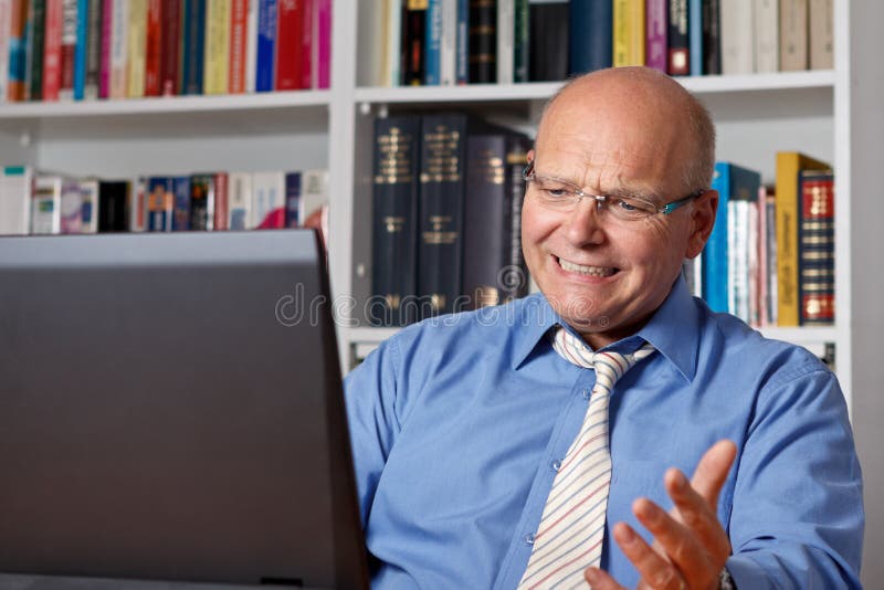 Homem idoso frustrado na frente do caderno imagens de stock Homem idoso frustrado na frente do caderno imagens de stock
