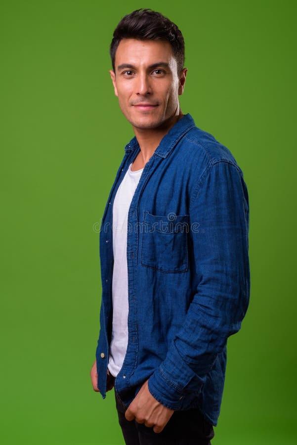 Homem latino-americano considerável novo contra o fundo verde fotografia de stock Homem latino-americano considerável novo contra o fundo verde fotografia de stock