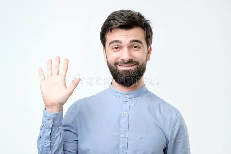 Homem latino-americano novo polido de vista amigável que diz olá! fotografia de stock Homem latino-americano novo polido de vista amigável que diz olá! fotografia de stock