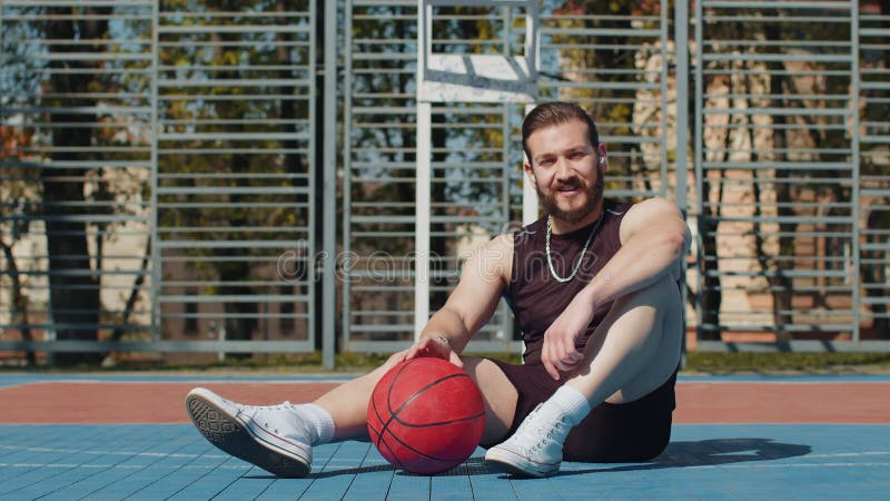 Um Homem Relaxando Depois Do Treino De Basquetebol E Pesquisando