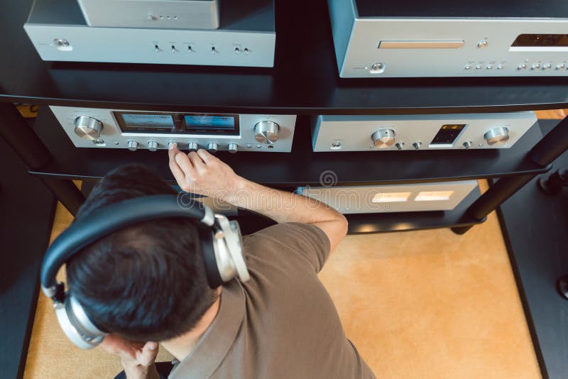 Homem a ligar o volume do aparelho de som Hi-Fi doméstico imagem de stock Homem a ligar o volume do aparelho de som Hi-Fi doméstico imagem de stock