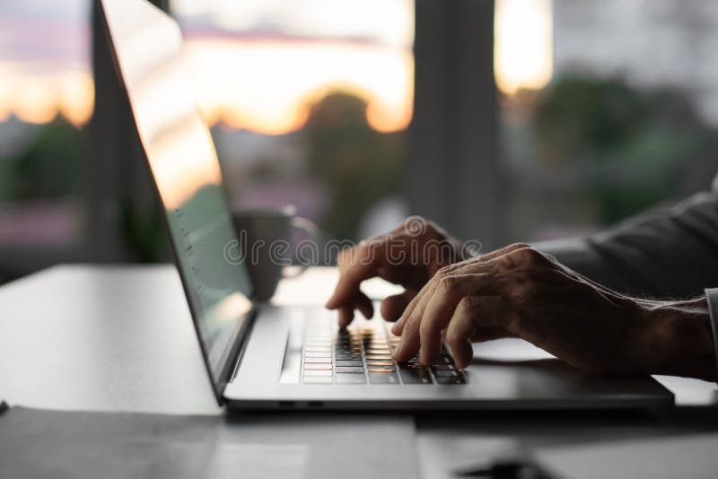 Feche a mão usando computador e teclado digitando na internet