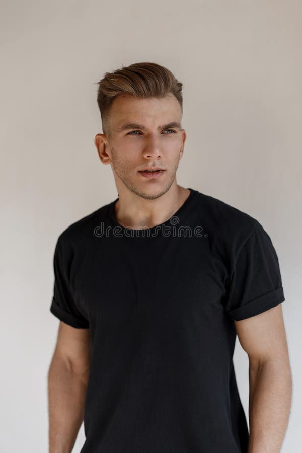 Homem modelo considerável elegante com penteado na camisa preta foto de stock Homem modelo considerável elegante com penteado na camisa preta foto de stock