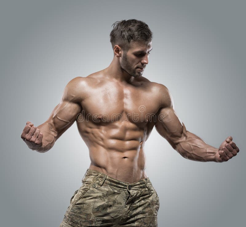 Homem muscular do halterofilista do atleta em um fundo cinzento imagens de stock royalty free Homem muscular do halterofilista do atleta em um fundo cinzento imagens de stock royalty free