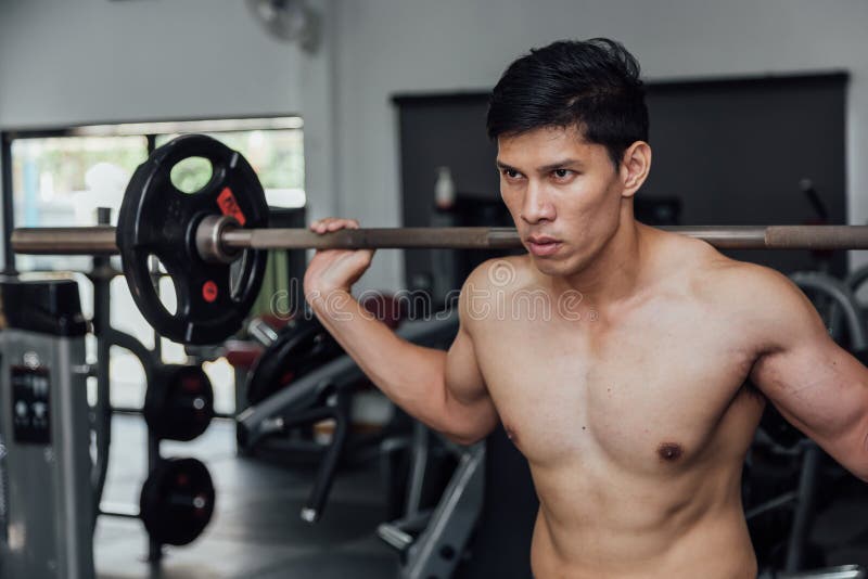 Homem muscular que d? certo no gym que faz exerc?cios com o barbell no b?ceps, homem forte imagens de stock royalty free Homem muscular que d? certo no gym que faz exerc?cios com o barbell no b?ceps, homem forte imagens de stock royalty free
