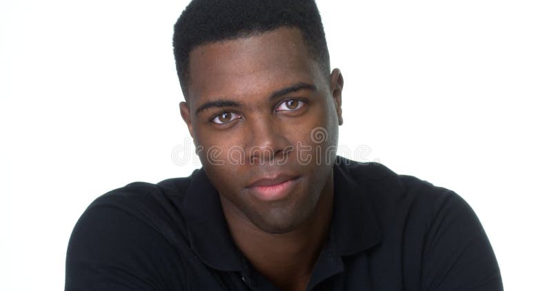 Homem negro novo atrativo que olha a câmera fotografia de stock Homem negro novo atrativo que olha a câmera fotografia de stock