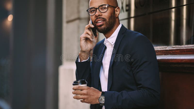 Homem no terno de negócio que fala sobre o telefone celular fora foto de stock royalty free Homem no terno de negócio que fala sobre o telefone celular fora foto de stock royalty free