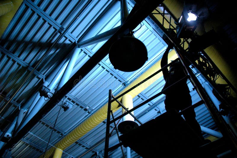 A man mounting light in an blue roof. A man mounting light in an blue roof