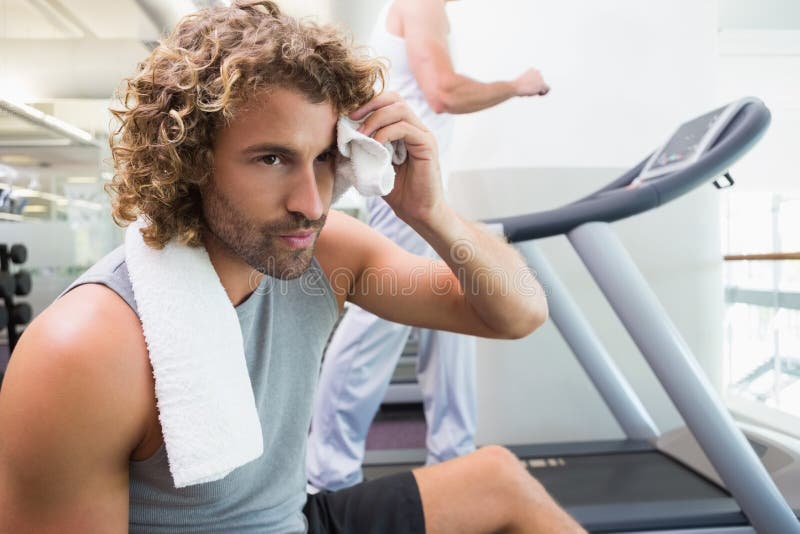 Homem novo cansado considerável no gym foto de stock Homem novo cansado considerável no gym foto de stock
