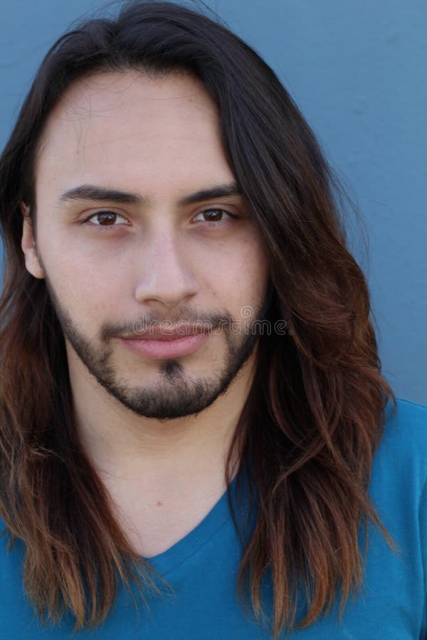 Young male with long hair and beard posing to the camera. Young male with long hair and beard posing to the camera.