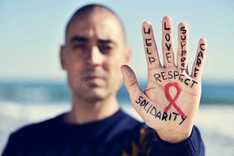 Homem novo com uma fita vermelha para a luta contra o SIDA em seu ha