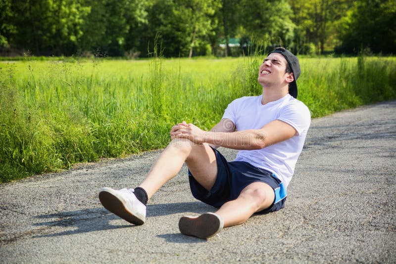 Homem novo considerável ferido ao correr e imagem de stock Homem novo considerável ferido ao correr e imagem de stock