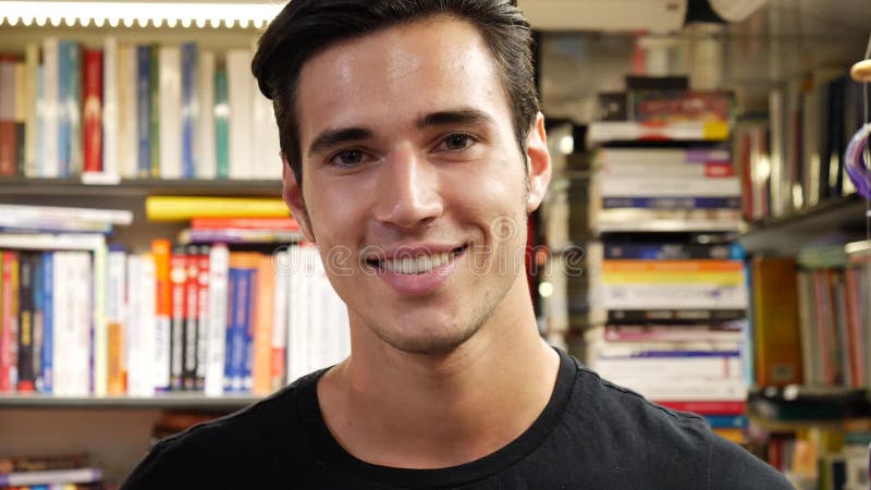 Homem novo considerável no sorriso da livraria