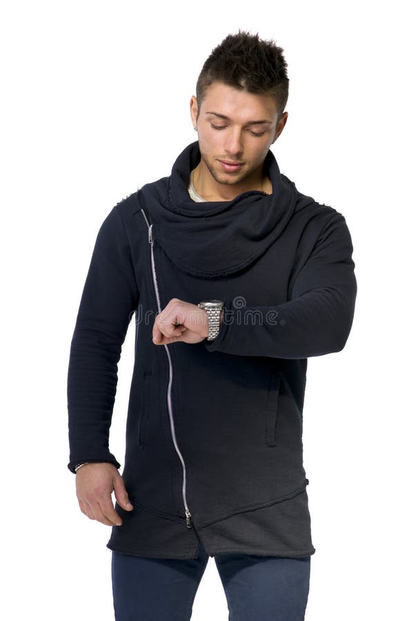 Homem novo considerável que verifica o relógio em seu pulso fotografia de stock royalty free Homem novo considerável que verifica o relógio em seu pulso fotografia de stock royalty free